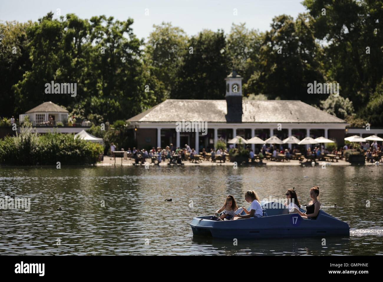 Menschen mit Tretboote auf dem Serpentine im Hyde Park, London, an einem warmen und sonnigen Tag. Stockfoto