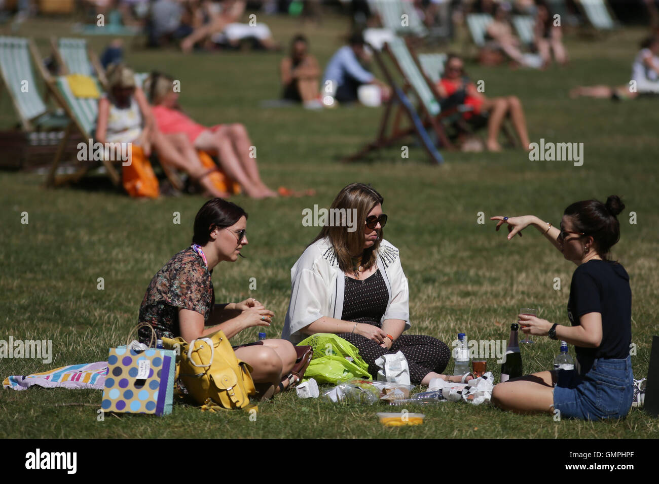 Eine Gruppe von Freunden genießen Sie das Wetter in Green Park, London, an einem warmen und sonnigen Tag. Stockfoto