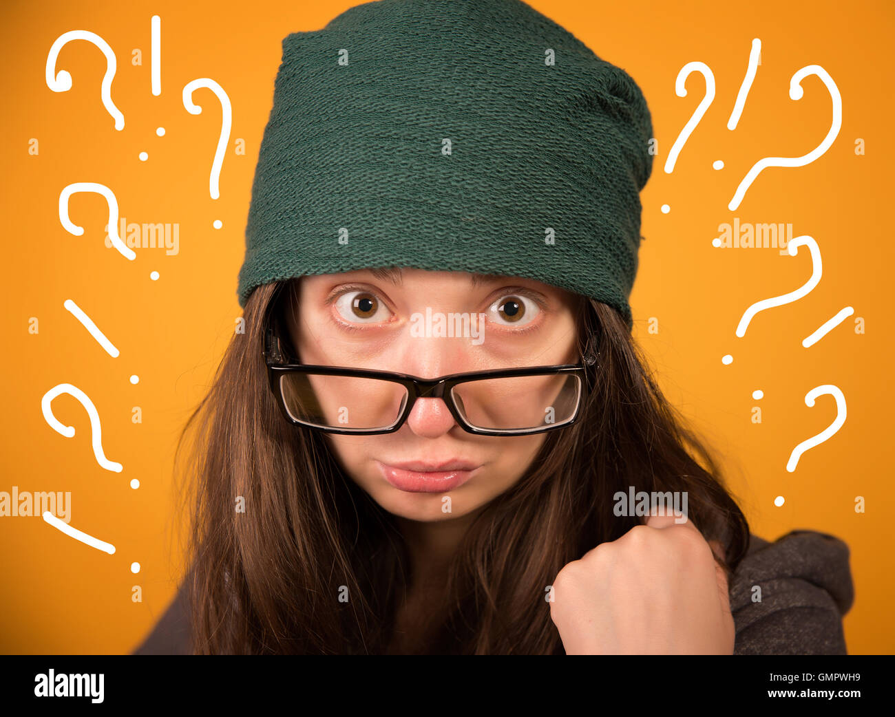 Das Mädchen mit Brille und Hut auf einem gelben Hintergrund Stockfoto