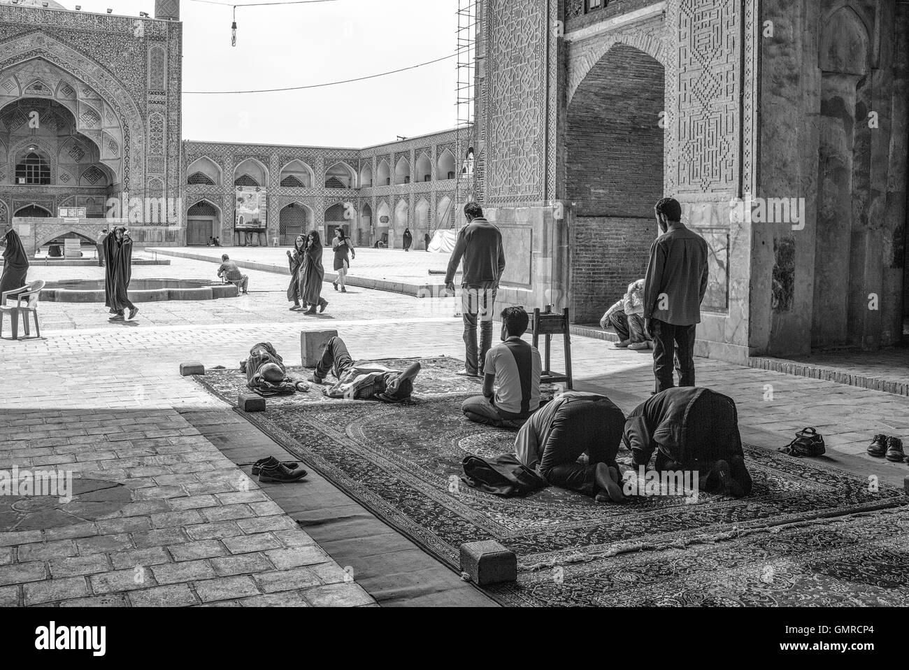 Die Jāmeh-Moschee von Isfahān ist die grand, Gemeinde Moschee (Jāmeh) Isfahān, Iran.  Männer treffen sich am Mittag Gebete, NAP und Unterhaltung. Monochrom. Stockfoto