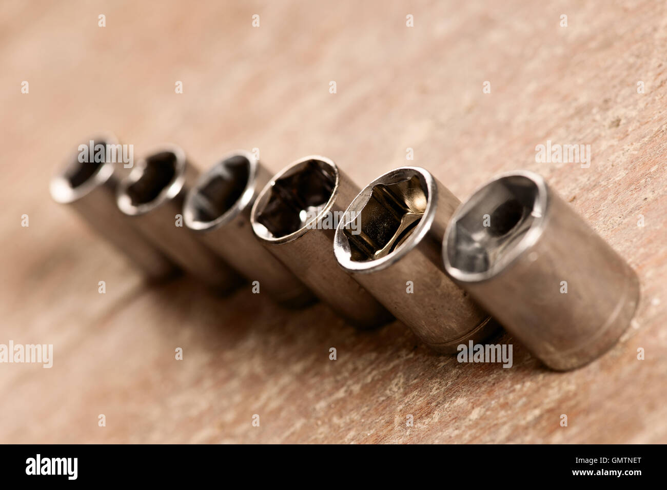 Rohrförmige Buchse Werkzeuge für Spanner Schraubenschlüssel stehen hintereinander am Schreibtisch aus Holz. Stockfoto