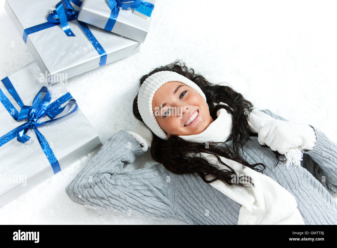 Ziemlich kaukasische Mädchen in Winterkleidung Verlegung auf einem verschneiten, weißen Hintergrund. Stockfoto