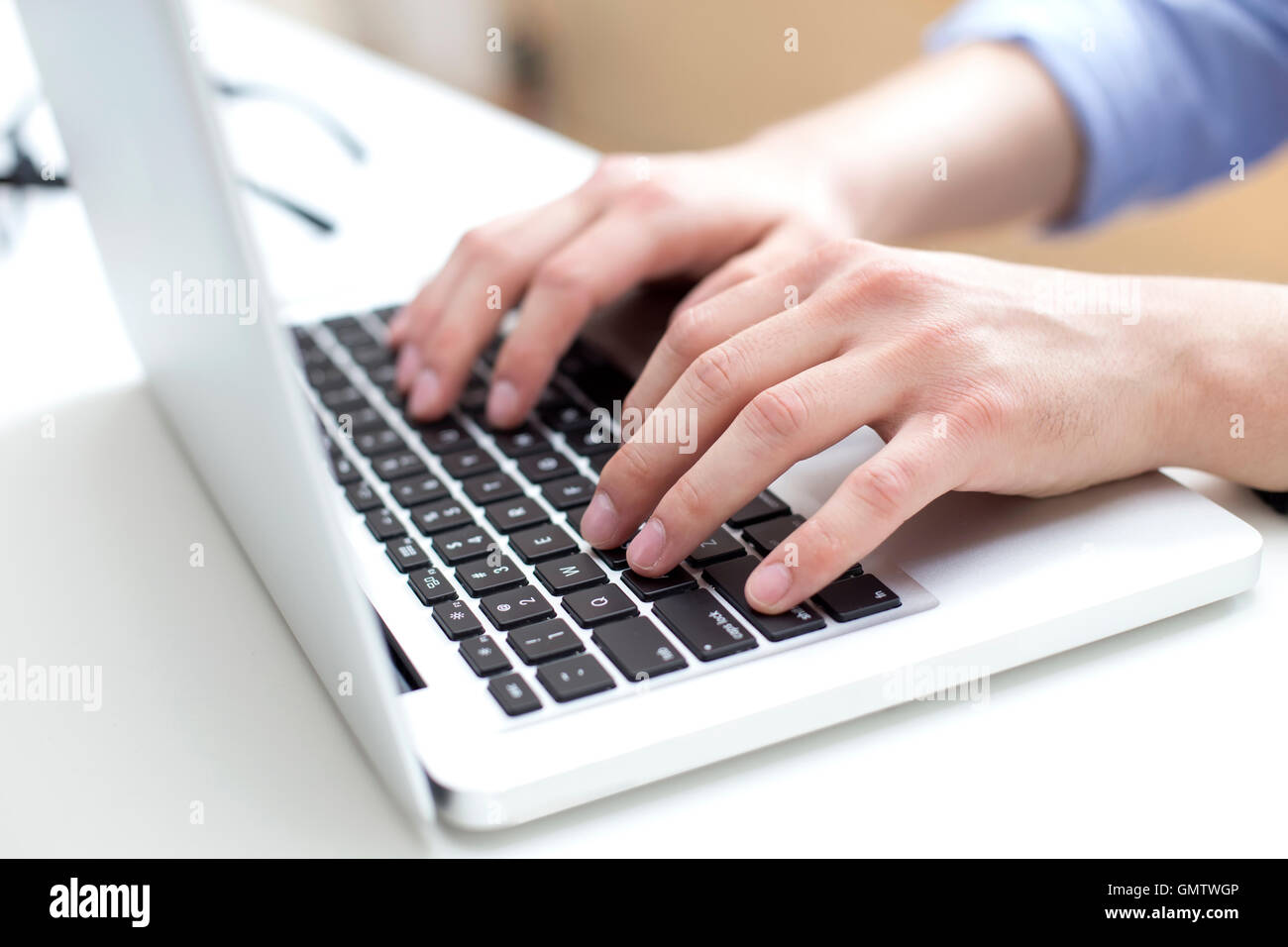 Junger Mann arbeiten am Laptop in He-Büro Stockfoto