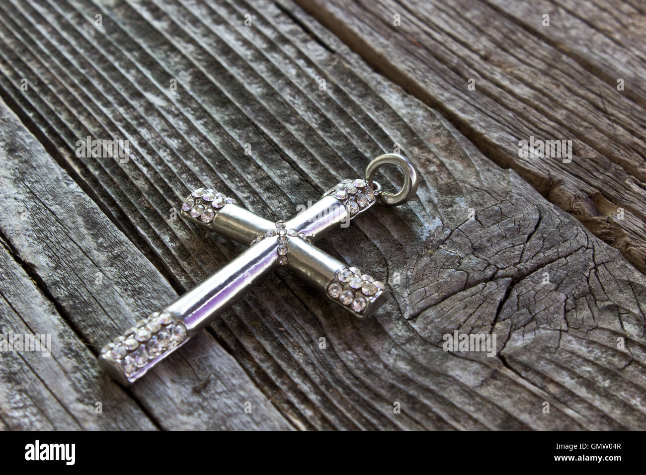 Silberne christlichen Kreuz auf hölzernen Hintergrund Stockfoto