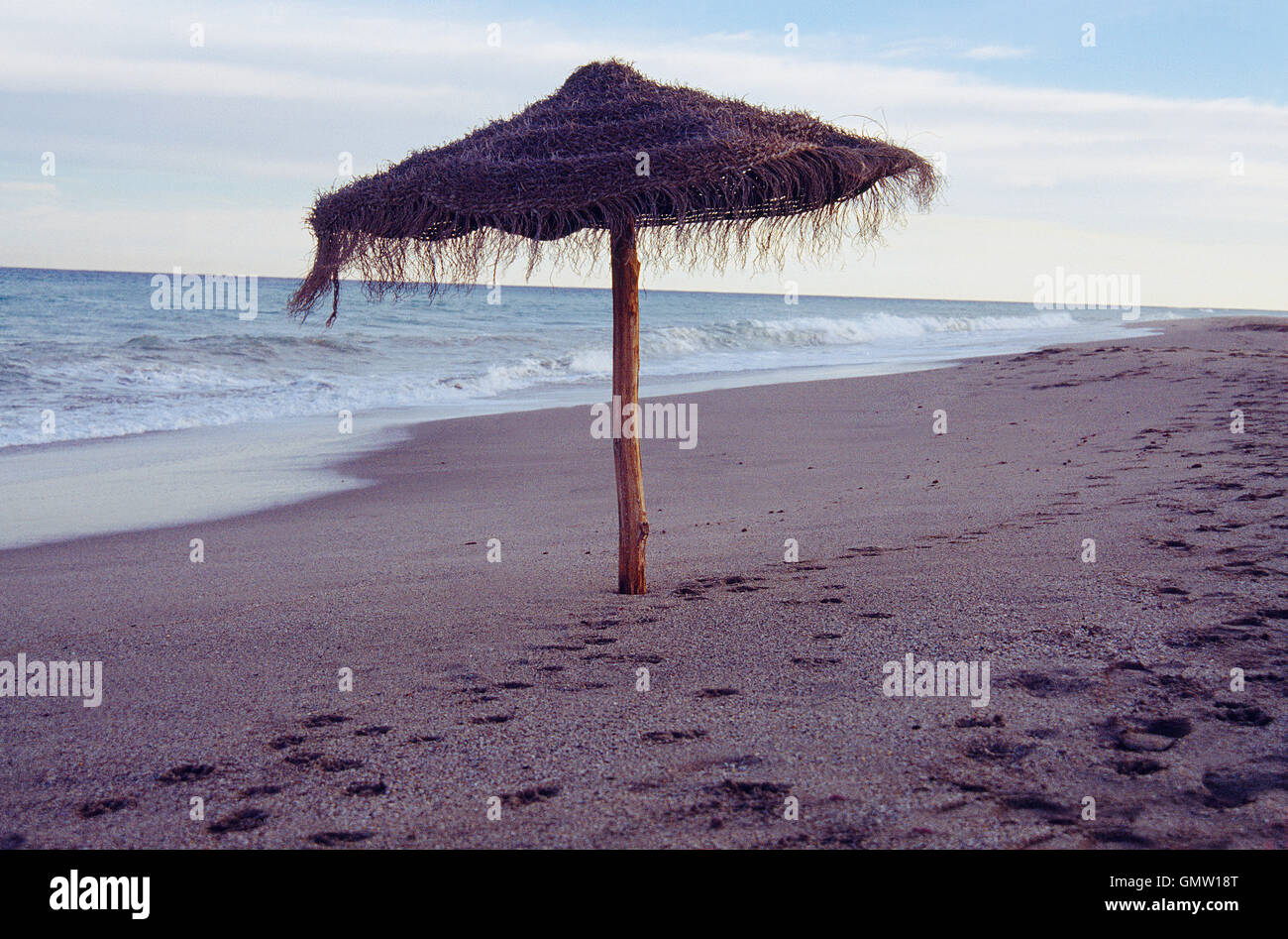 Sonnenschirm in einsamen Strand in der Abenddämmerung. Mojacar, Provinz Almeria, Andalusien, Spanien. Stockfoto
