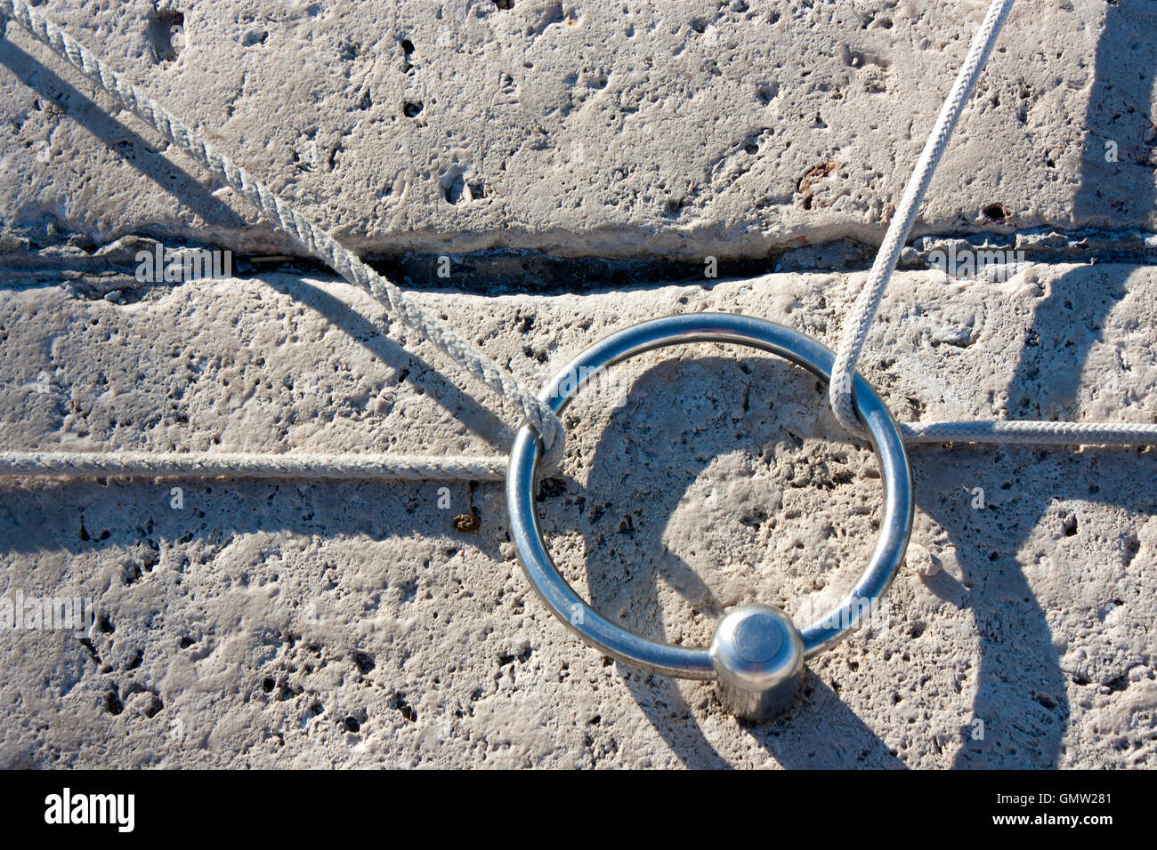 Poller aus Edelstahl Ring auf dem steinernen Pier mit Seilen für zwei Segelboote Stockfoto