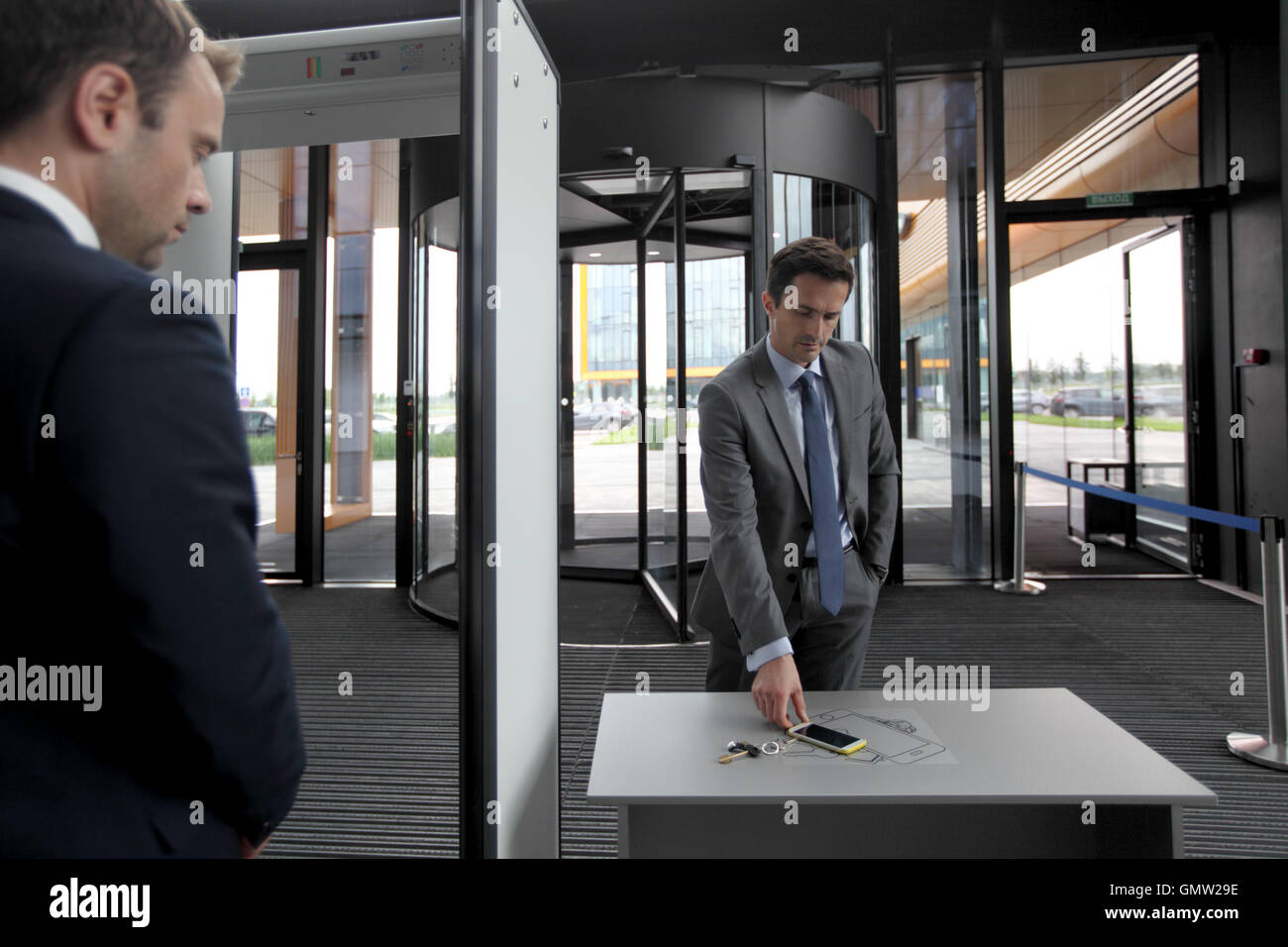 Mann am Flughafen Sicherheitsschleusen Außerbetriebnahme Telefon und Schlüssel Stockfoto