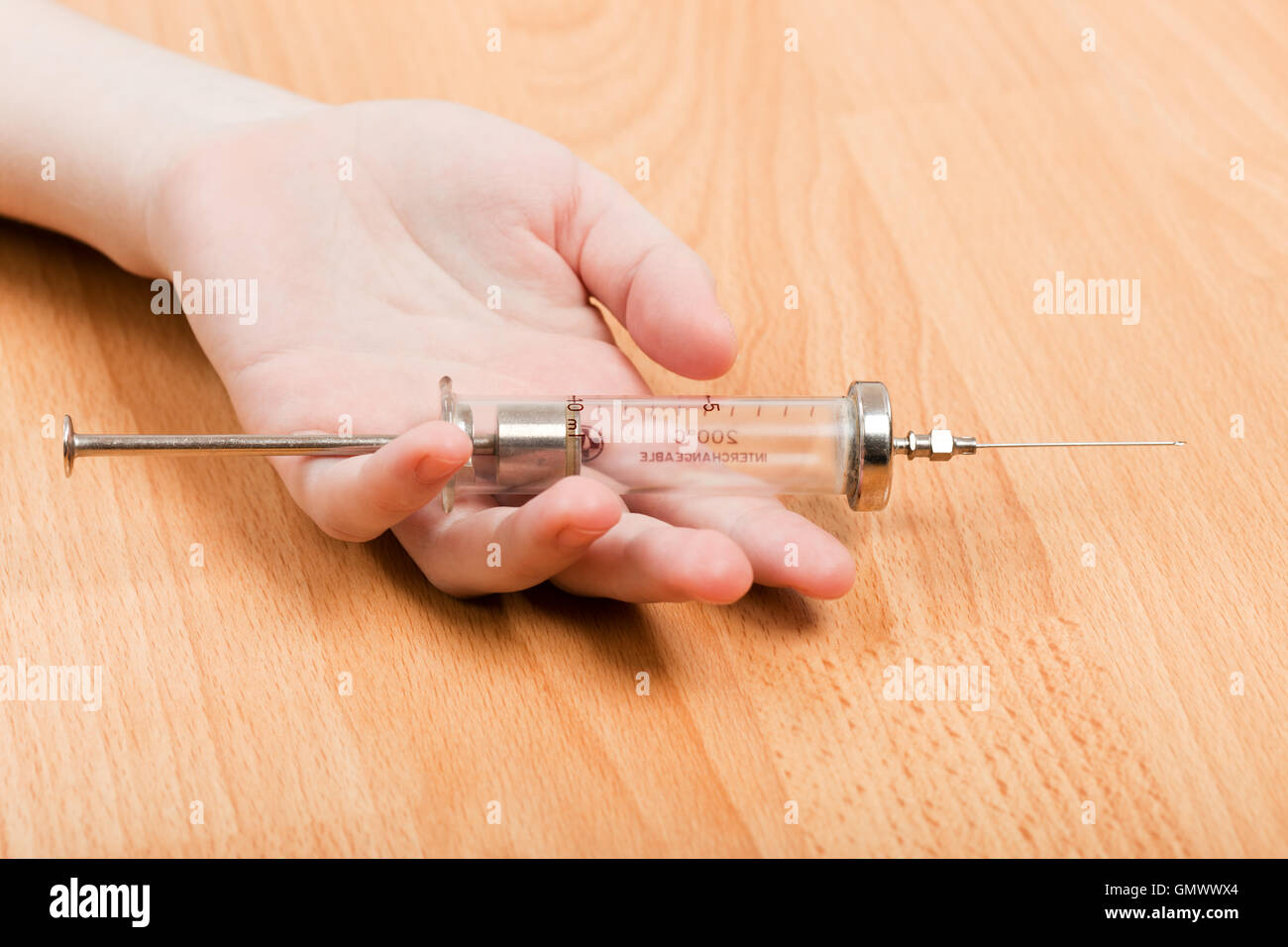 Spritze in der Hand der Süchtigen Stockfoto