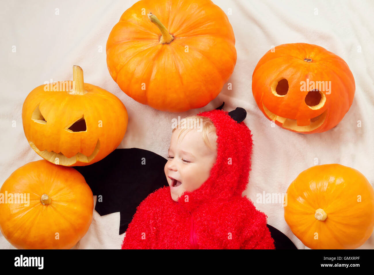 Baby Teufel Kostüm mit Kürbissen Stockfoto