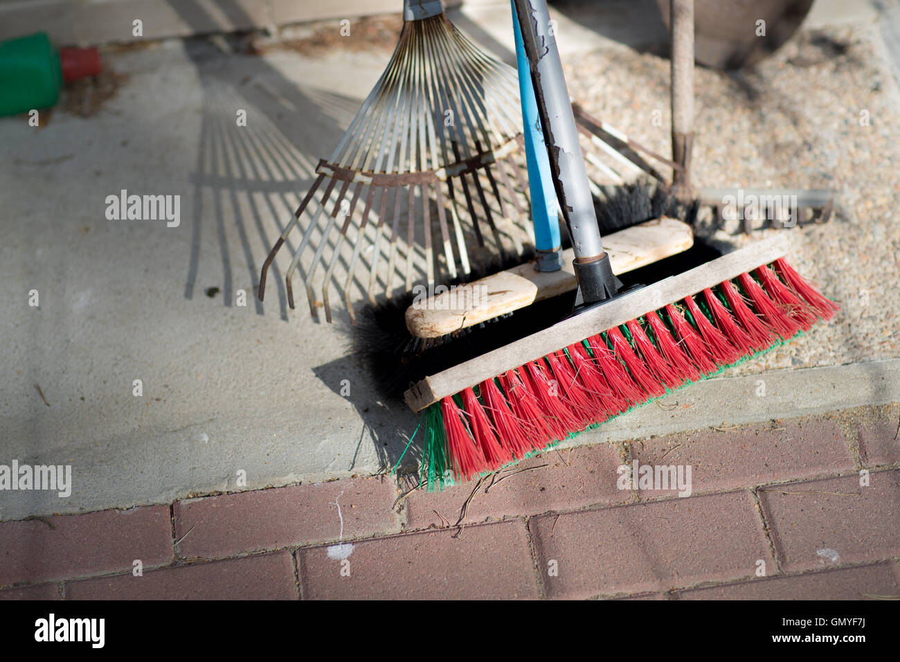 Garten und Reinigungs-Tools lehnt sich an eine Wand (Pinsel, Rechen, etc.) Stockfoto