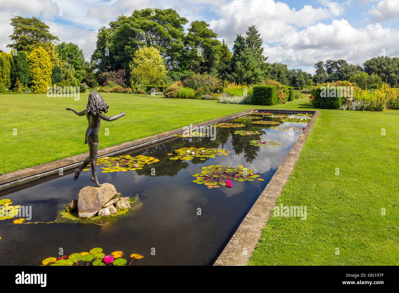 Die bunten Seerosenteich mit einer Statue des jungen Mädchens an der Waterperry Gärten, Oxfordshire, England, UK Stockfoto