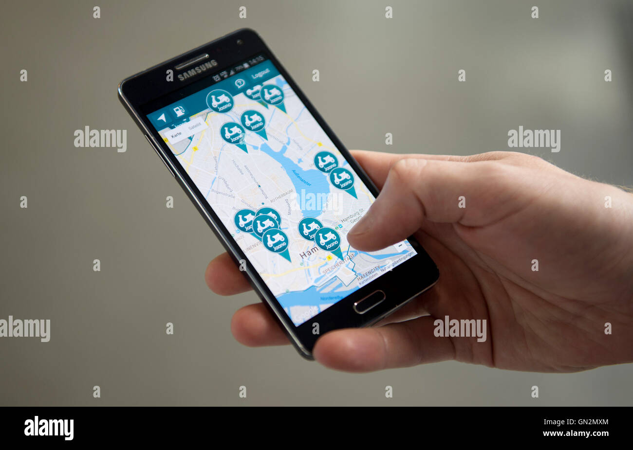 Hamburg, Deutschland. 19. August 2016. Ein Mann nutzt die mobile app von Scooter Freigabedienstanbieter "Jaano" in Hamburg, Deutschland, 19. August 2016. Auto-sharing-Anbieter im deutschen Markt bereits erobert haben, aber inzwischen haben die Zweiräder auch Kontrolle über den Austausch von Markt genommen. Foto: Daniel Reinhardt/Dpa/Alamy Live News Stockfoto