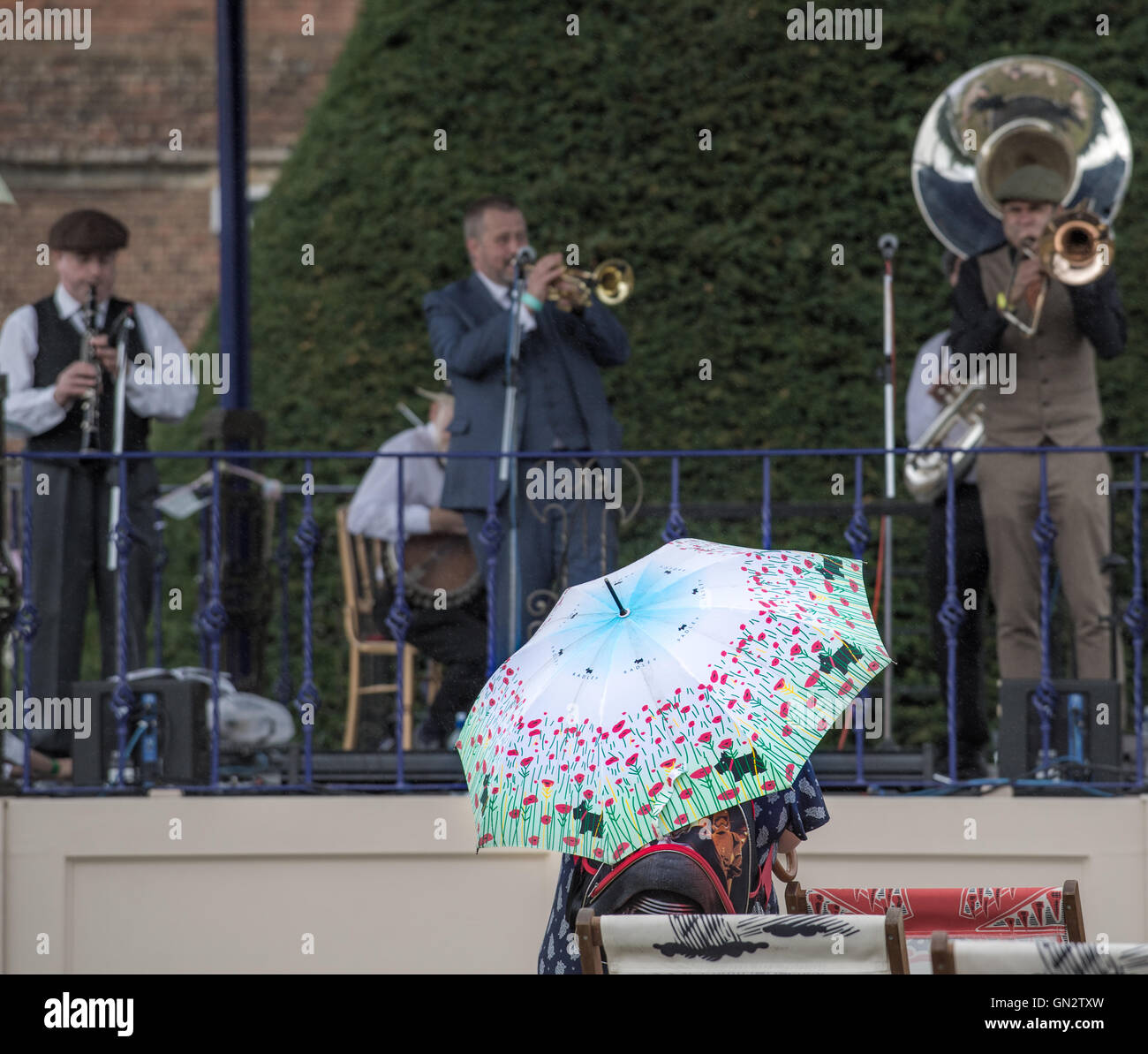 Hampton Court, London, UK. 28. August 2016. Einsamer Zuschauer bei dem Musikpavillon schützt sich vor dem Regen das BBC Good Food Festival auf dem Gelände des Hampton Court, London, am 28 august 2016 Credit: Vermischtes/Alamy Live News Stockfoto