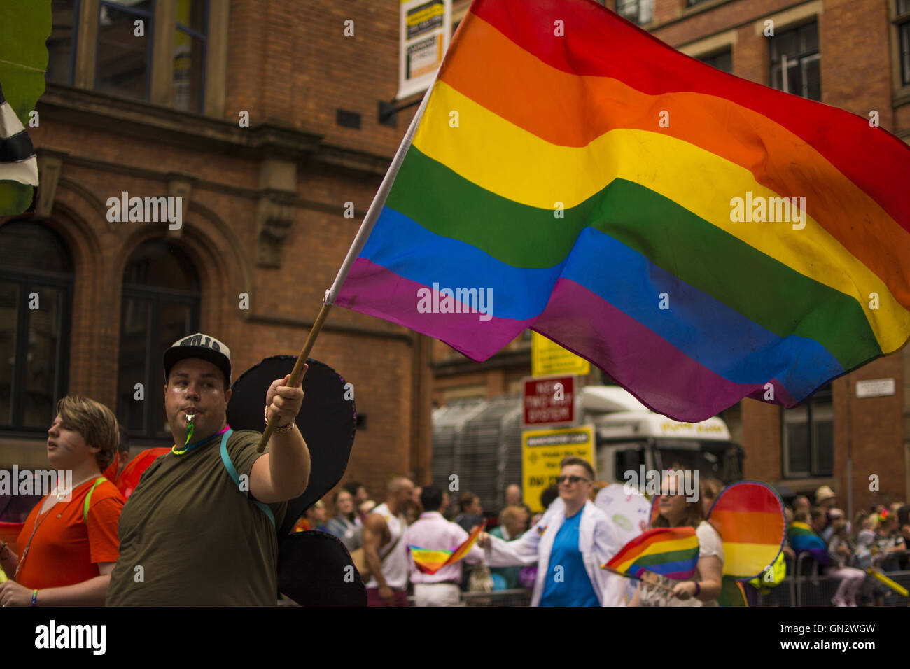 Manchester, UK. 27. August 2016. Manchester-Pride-Parade. Mann trägt Flügel Wellen gay-Pride-Flagge Credit: Tom McLoughlin/Alamy Live News Stockfoto