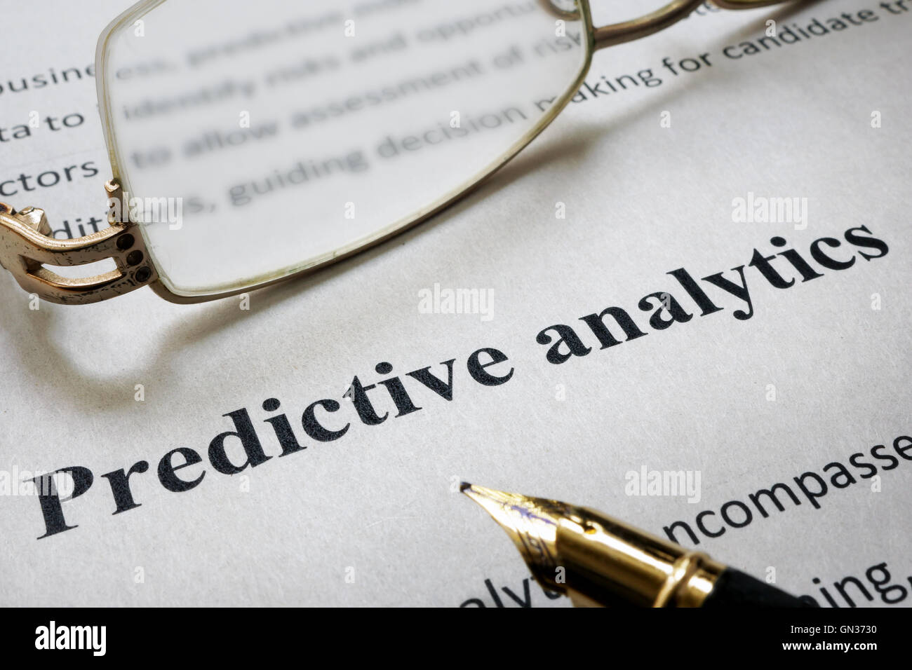 Seite des Papiers mit Worten Predictive Analytics und Gläser. Stockfoto