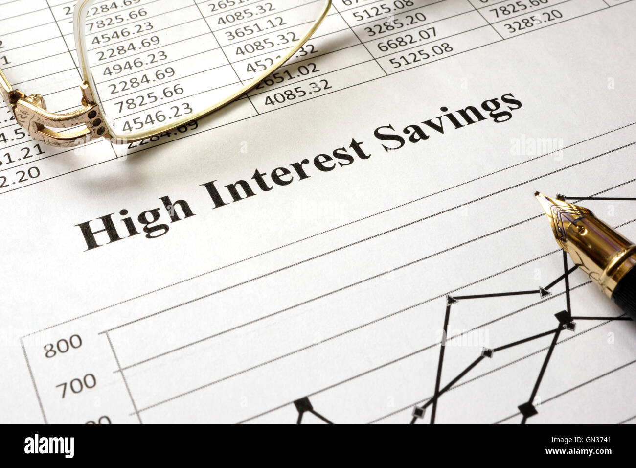 Melden Sie hohe Zinsersparnisse auf ein Blatt Papier und Gläser. Stockfoto