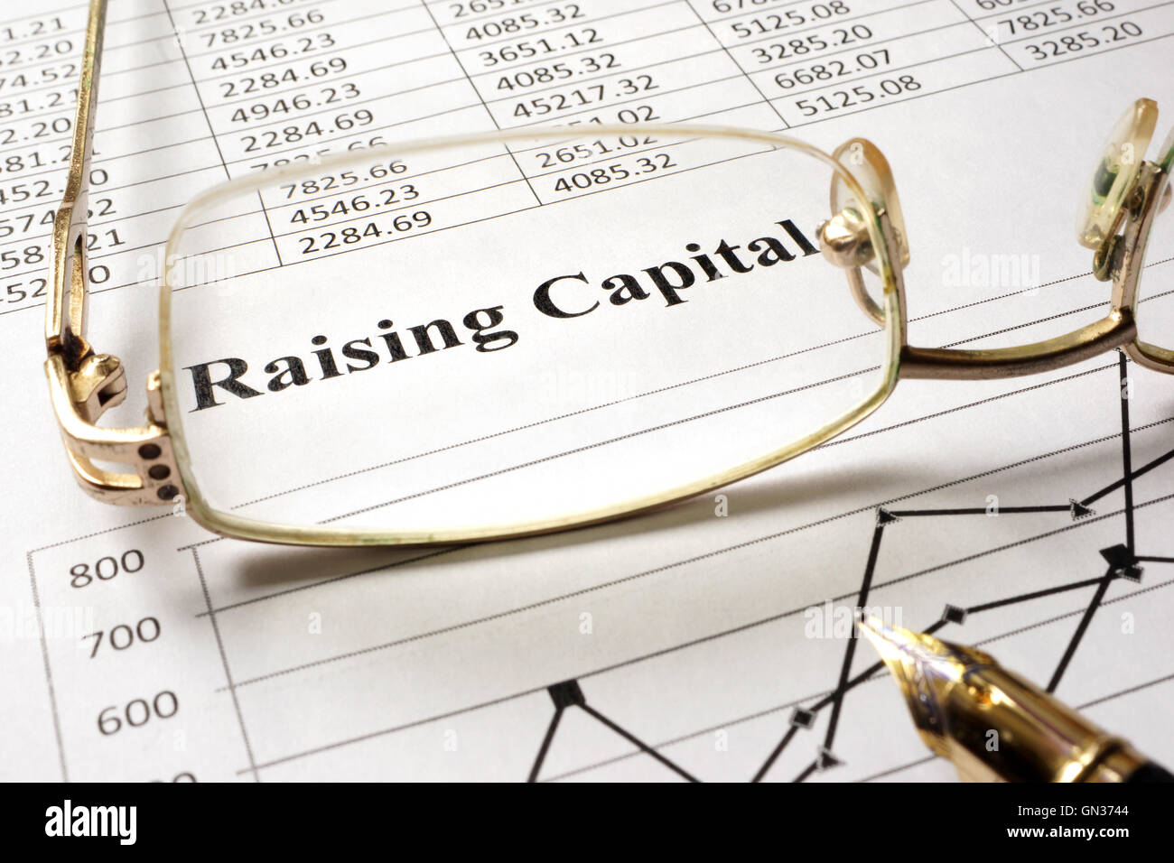 Zeichen, die Beschaffung von Kapital auf ein Blatt Papier und Gläser. Stockfoto