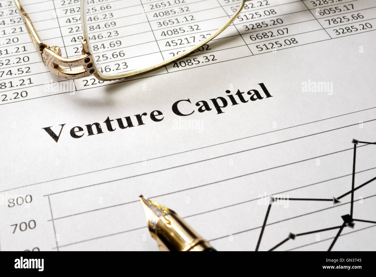 Venture Capital auf ein Blatt Papier und Gläser zu unterzeichnen. Stockfoto
