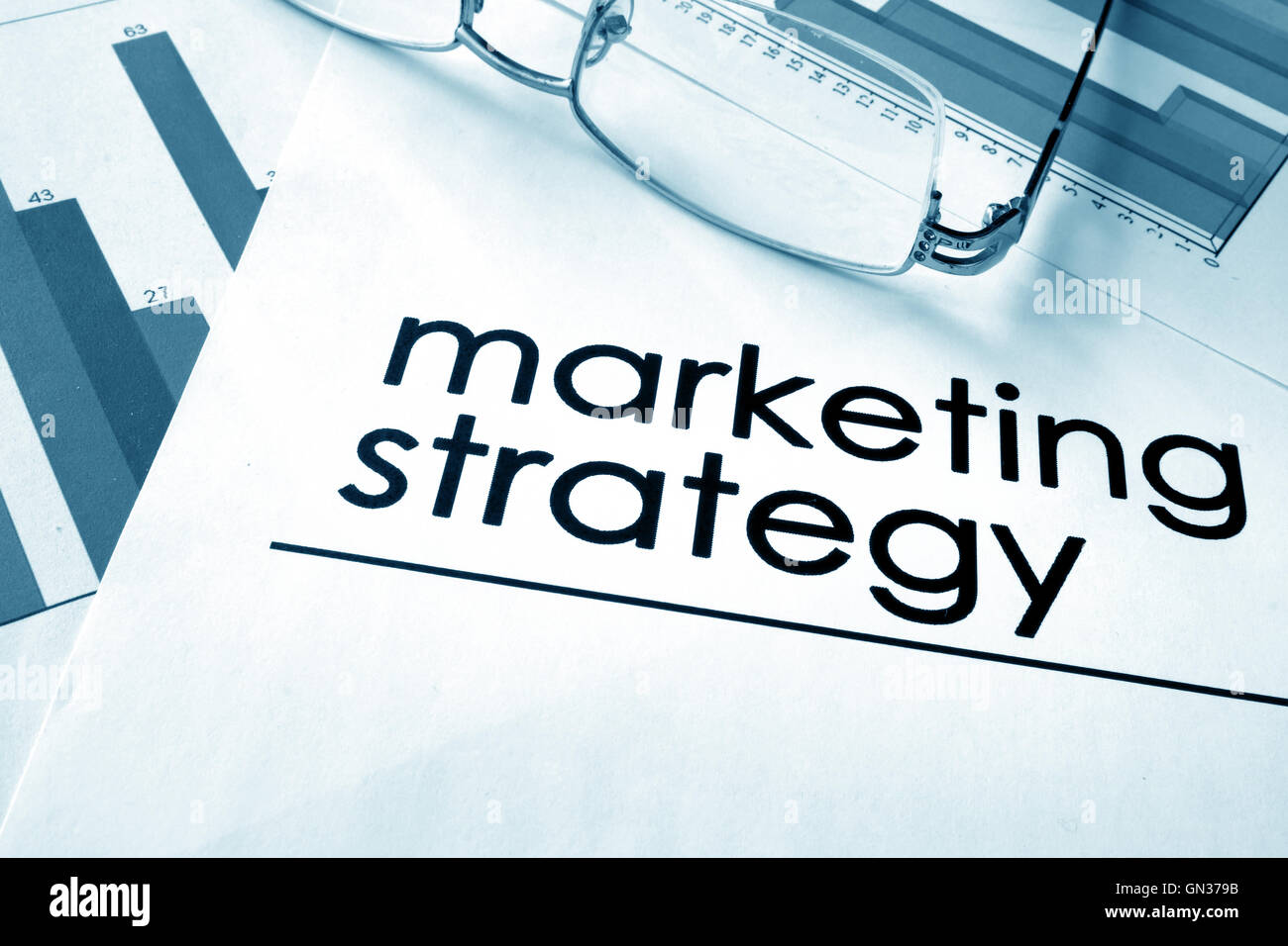 Papier mit Worten, die Marketingstrategie und Diagramme. Stockfoto