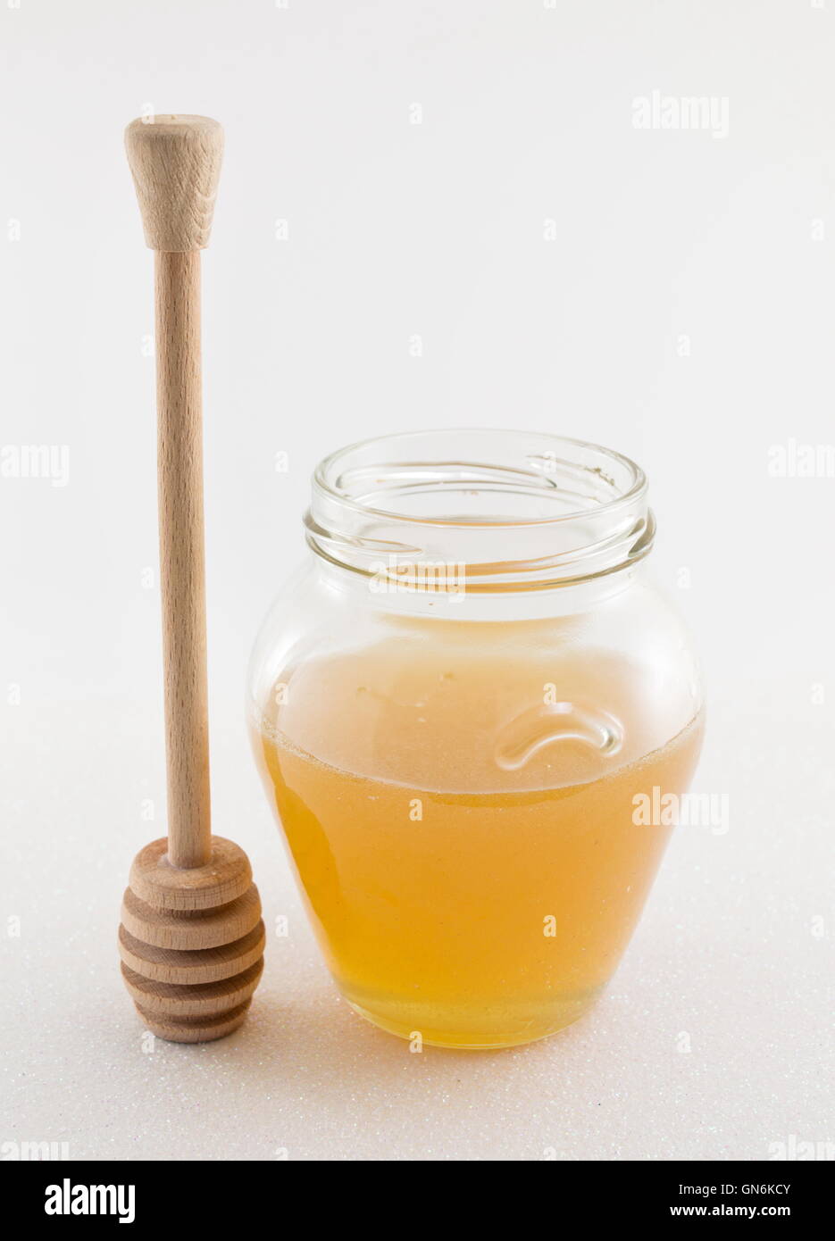 Glas Honig auf weißen glänzenden Hintergrund Stockfoto