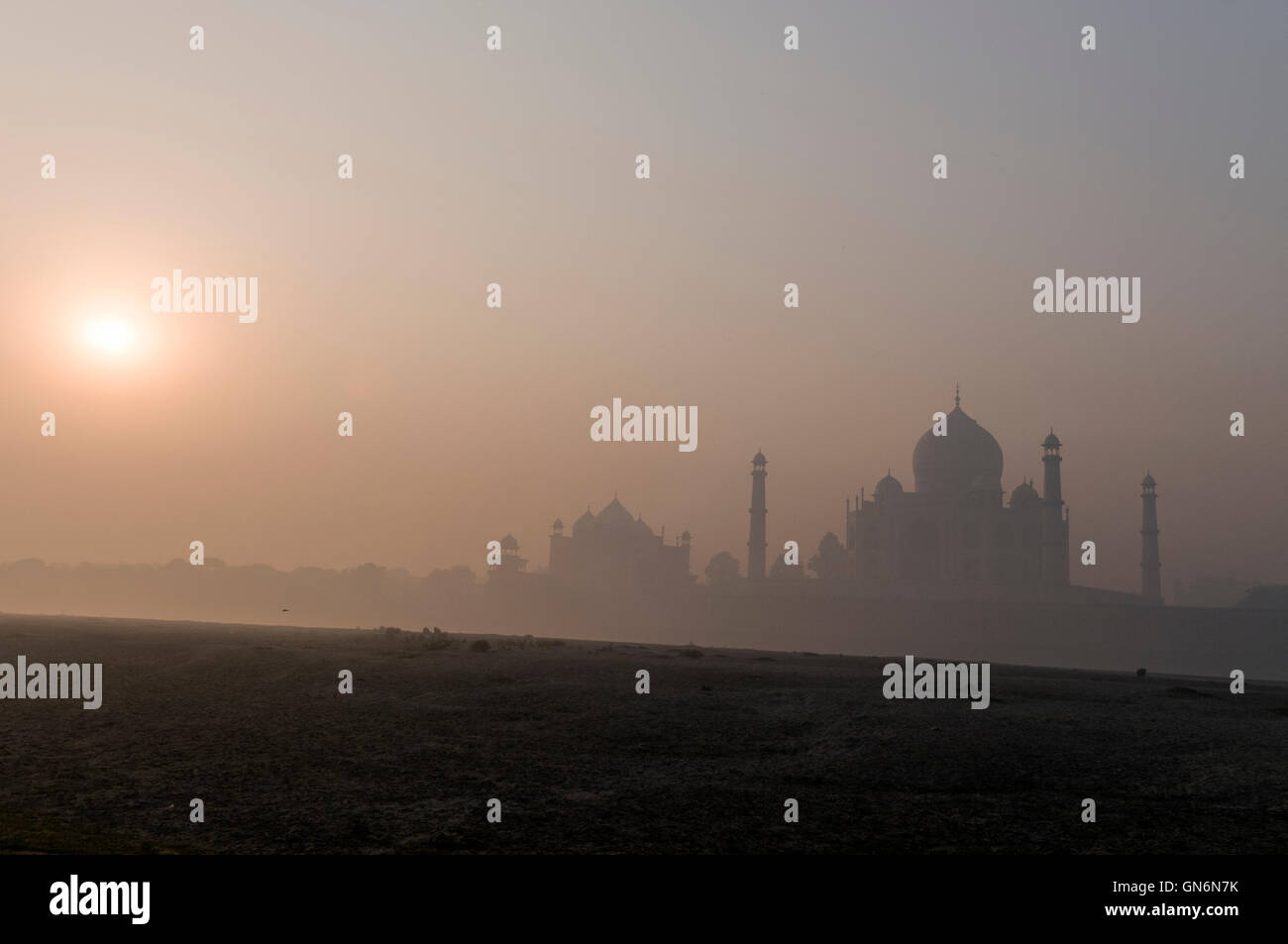 Die aufgehende Sonne im frühen Morgennebel über dem Taj Mahal in Agra, Uttar Pradesh, Indien Stockfoto