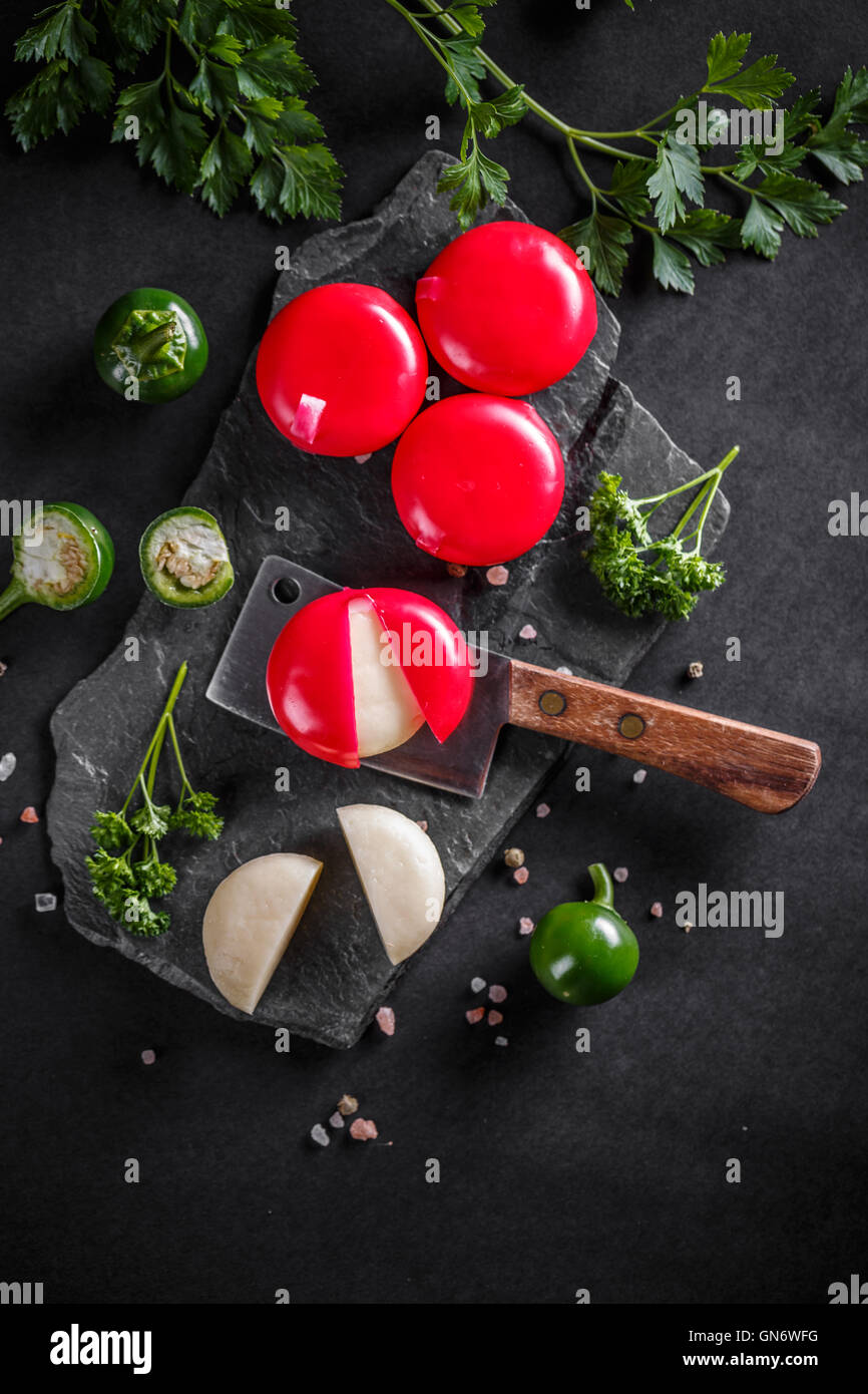 Rot gewachste Gourmet-Käse auf schwarzem Schiefer Stockfoto