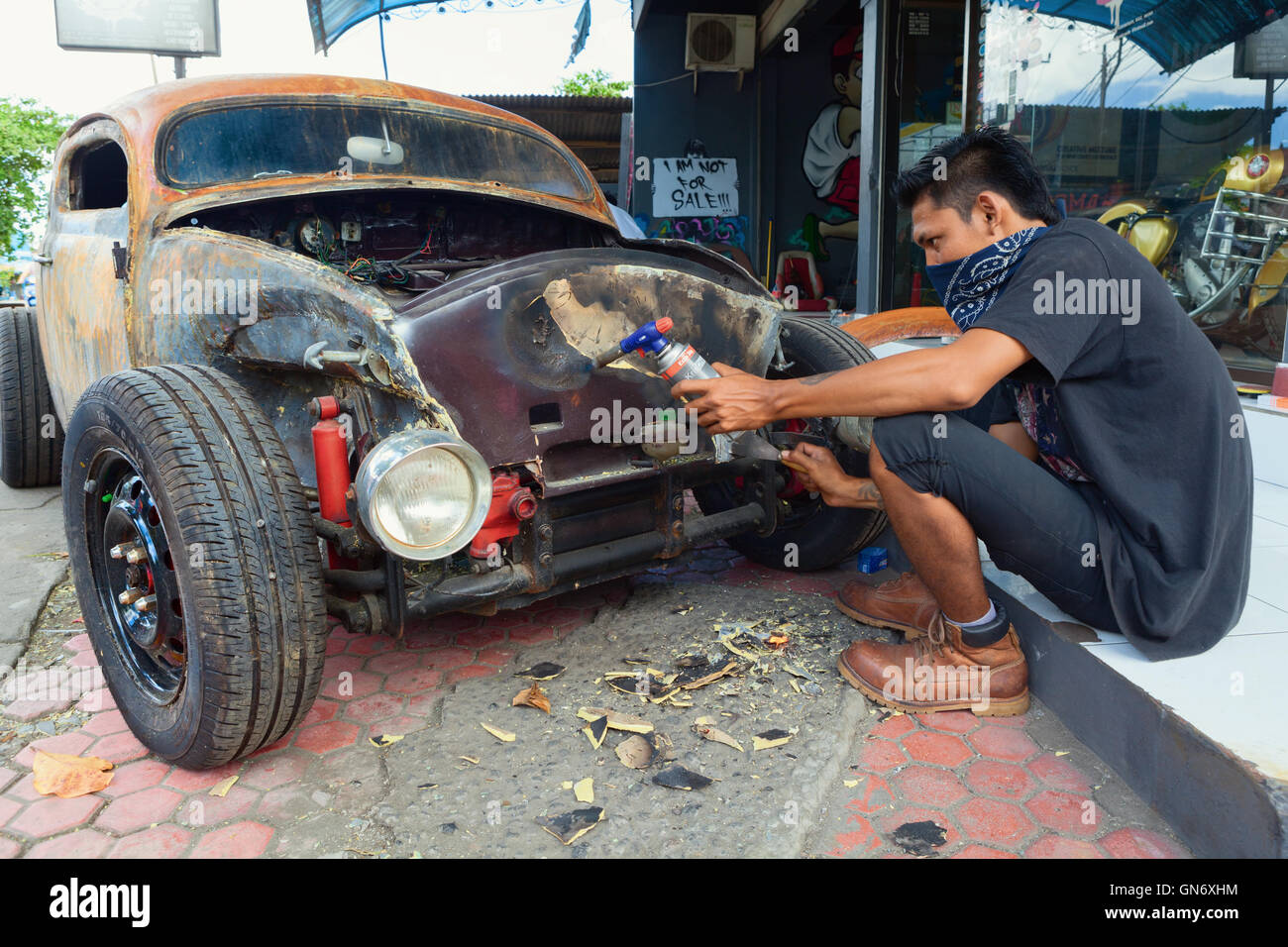 BALI, Indonesien - März 20: Junge Balinese Mann reinigt Körper eines alten VW-Käfer bei benutzerdefinierten Oldtimer. Stockfoto