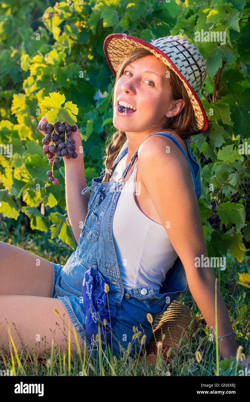 Glückliche Frau genießen frische Trauben im Weinberg Stockfoto