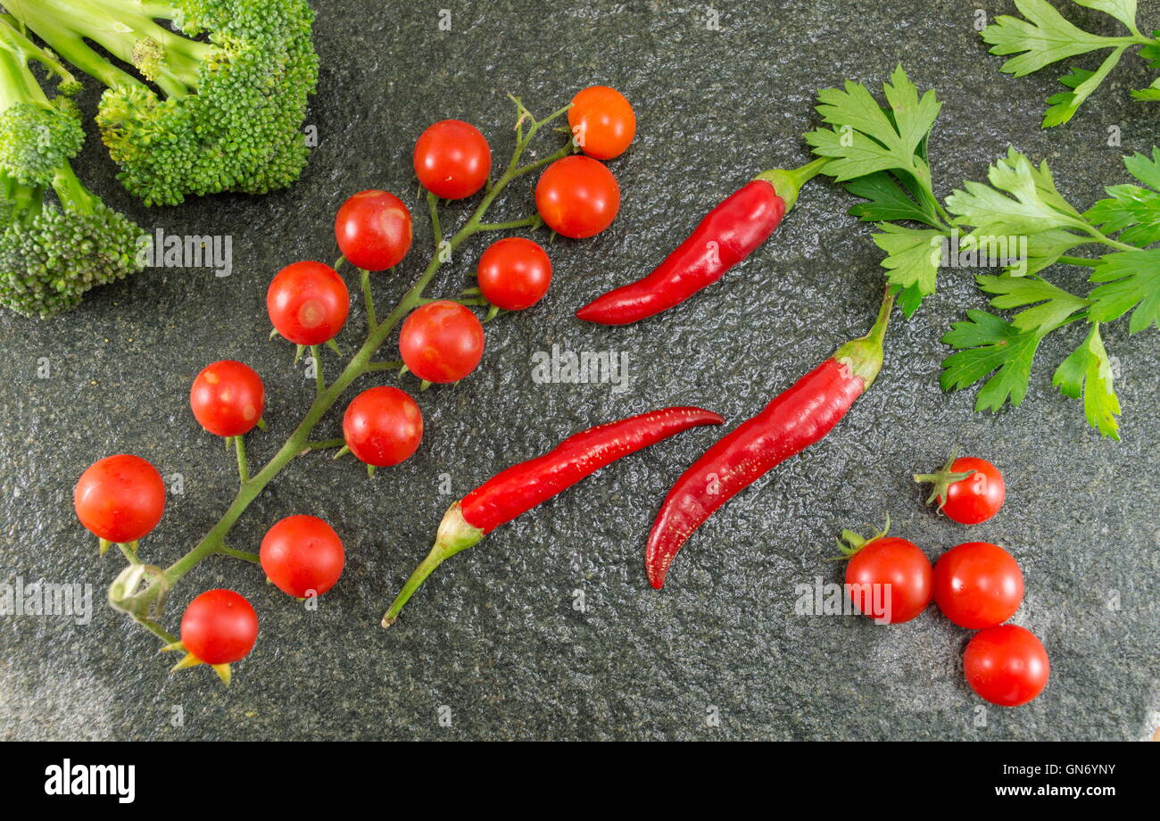Rohe Tomaten und Paprika auf Stein Hintergrund Stockfoto