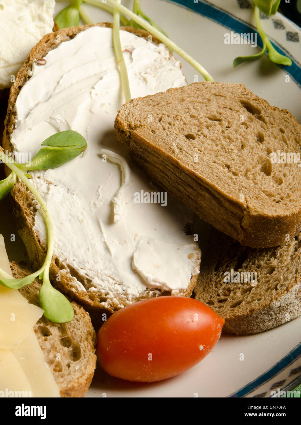 Gesunder Snack Vollkornbrot mit Frischkäse, Sprossen und Tomaten Stockfoto