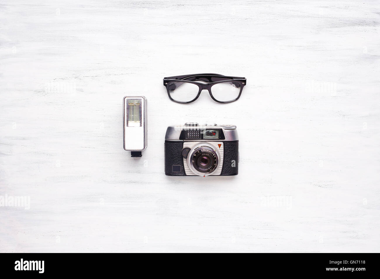 Draufsicht der Vintage Kamera und Hipster Gläser auf einem weißen Holztisch mit Exemplar. Stockfoto