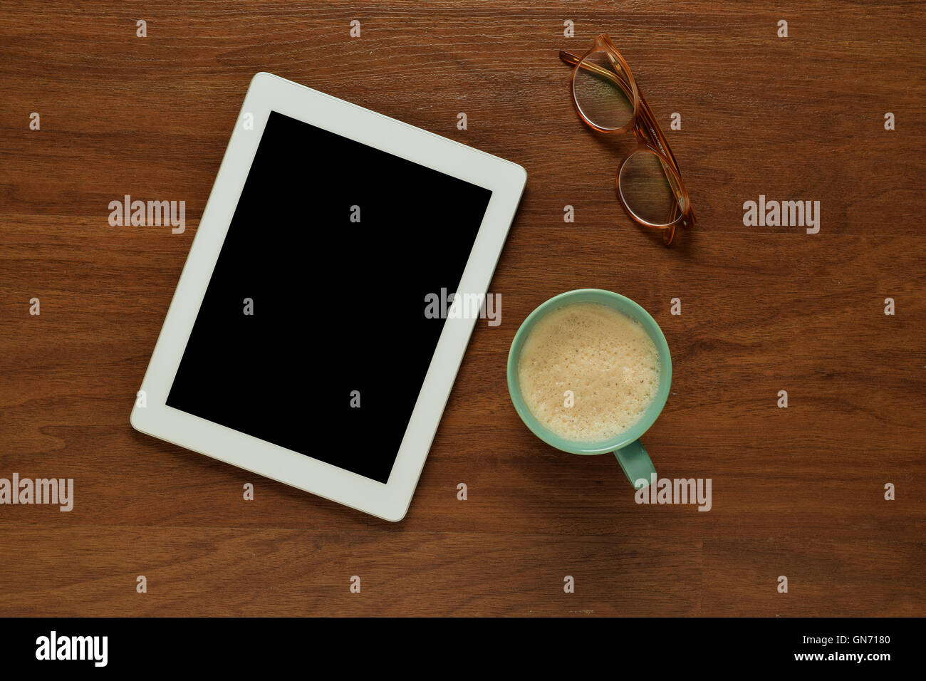 Draufsicht der Tablet-Computer, Gläser und eine Tasse Kaffee auf einem hölzernen Tisch mit Exemplar. Home Office und Lifestyle Konzept. Stockfoto
