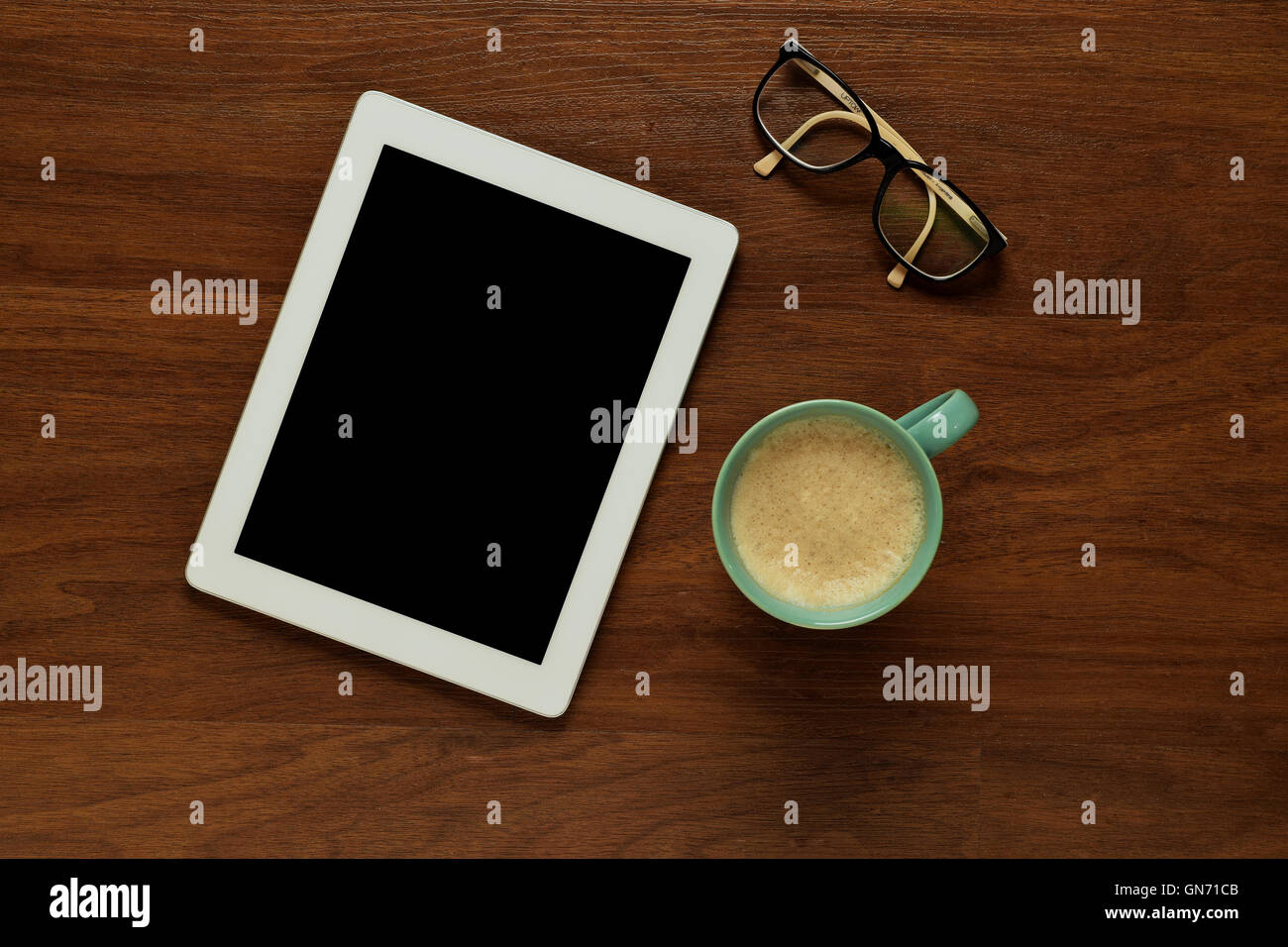 Draufsicht der Tablet-Computer, Gläser und eine Tasse Kaffee auf einem hölzernen Tisch mit Exemplar. Home Office und Lifestyle Konzept. Stockfoto