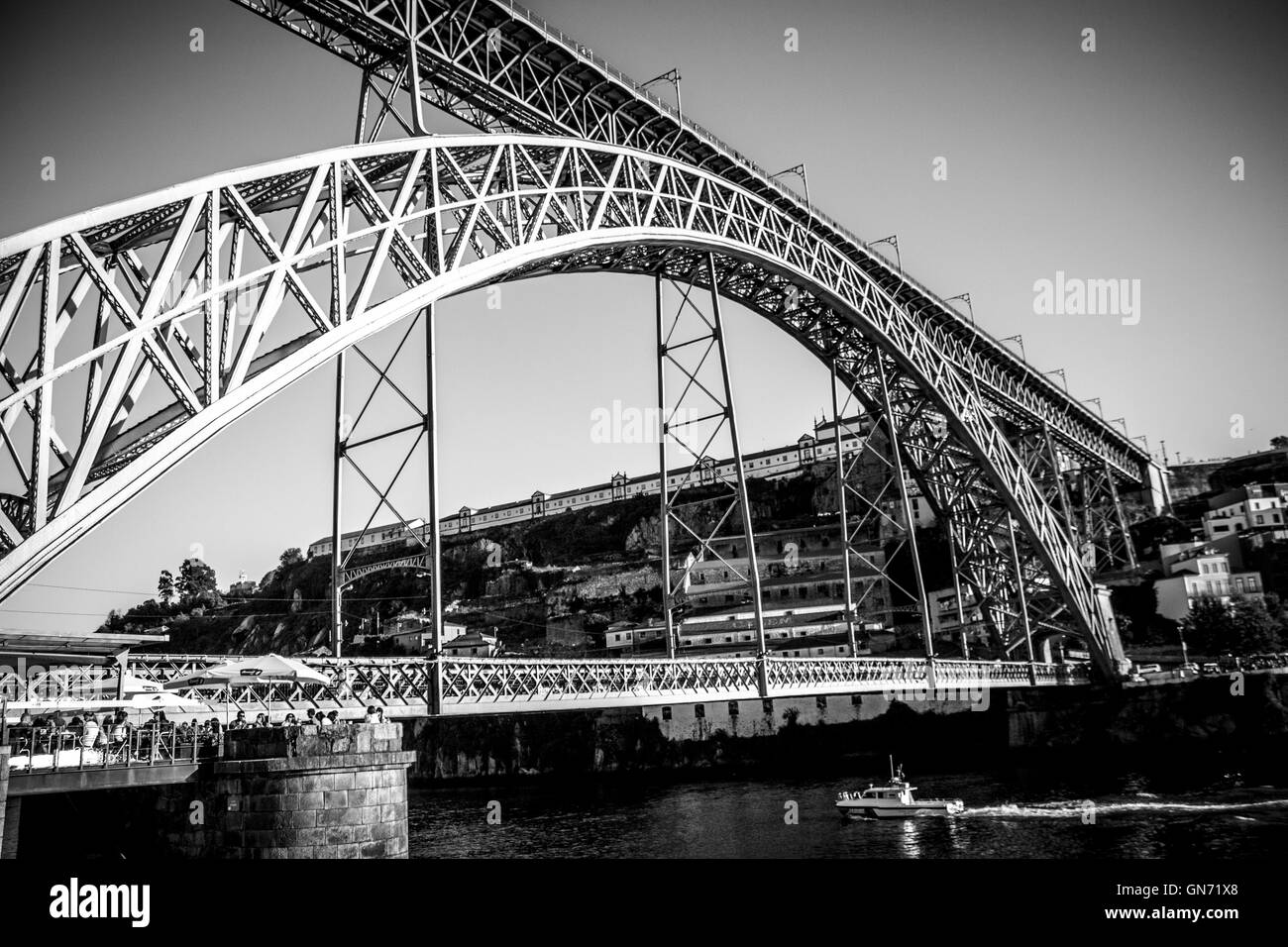 D. Luiz Brücke in Porto, Portugal. Schwarz und weiß mit Vignettierung und ein Boot über den Fluss Stockfoto