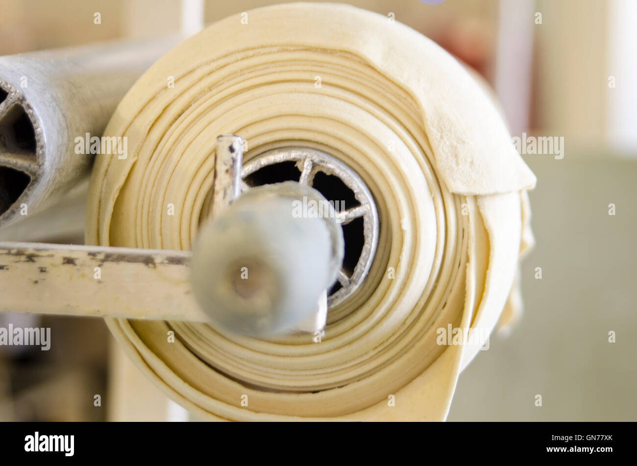 Großbäckerei. Frischen Teig auf eine Walzmaschine Stockfoto