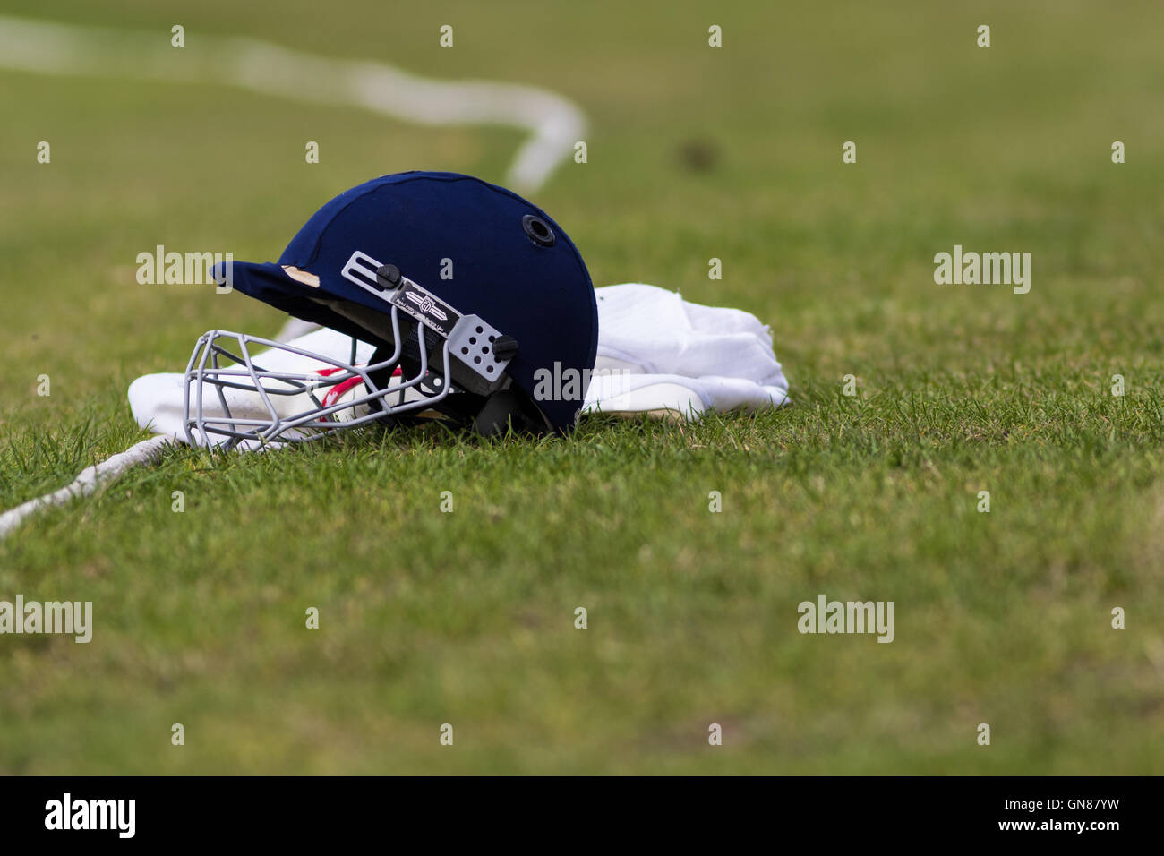 Cricket-Helm auf Cricket Pitch Begrenzung Seil Stockfoto