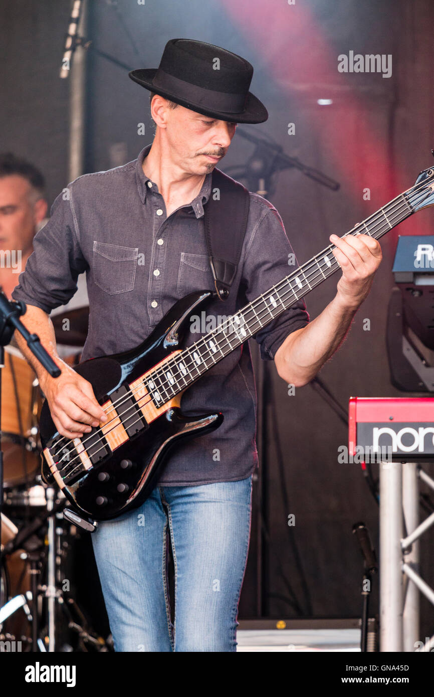 England. Kaukasische Mann, Nigel Hardstone, mit schwarzen Hut, Schleifen auf der Bühne spielte Bass Gitarre bei einem Konzert von Rock Gruppe Absatz 1. Close Up. Stockfoto