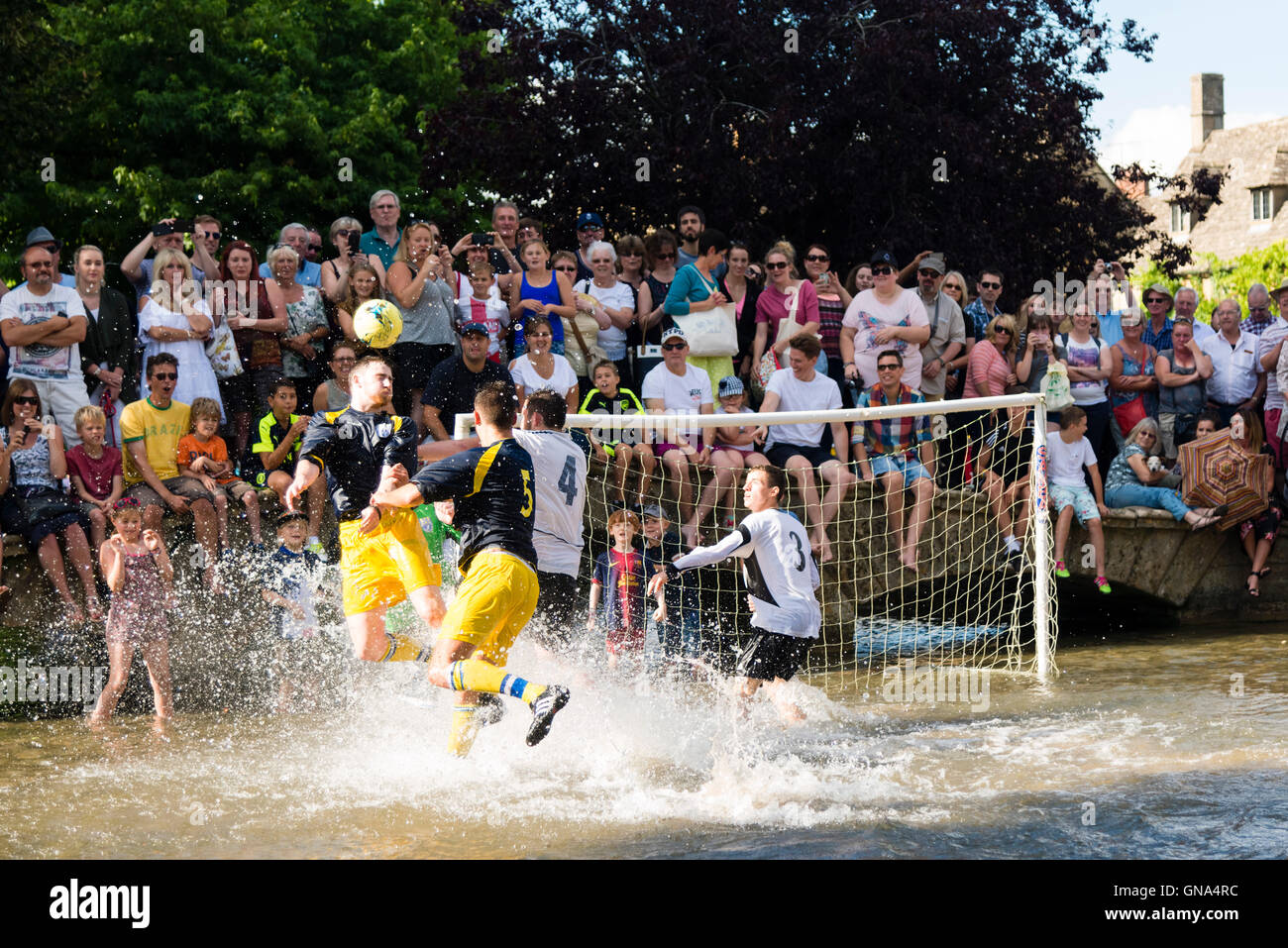 Cotswolds, UK. 29. August 2016. Bourton-on-the-Water-Fußball in den Fluss Windrush, August Bank Holiday Montag, Cotswolds, UK. Bildnachweis: Robert Convery/Alamy Live-Nachrichten Stockfoto