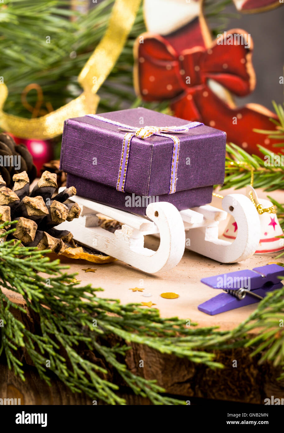 Geschenk-Box auf Schlitten unter Weihnachtsschmuck Stockfoto