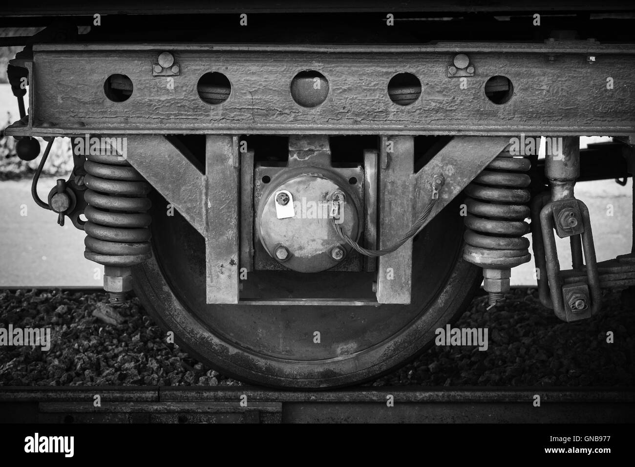 Alte Eisenbahn Wagen Rad mit Aufhängung Details, stilisierte Schwarz-weiß Foto Stockfoto