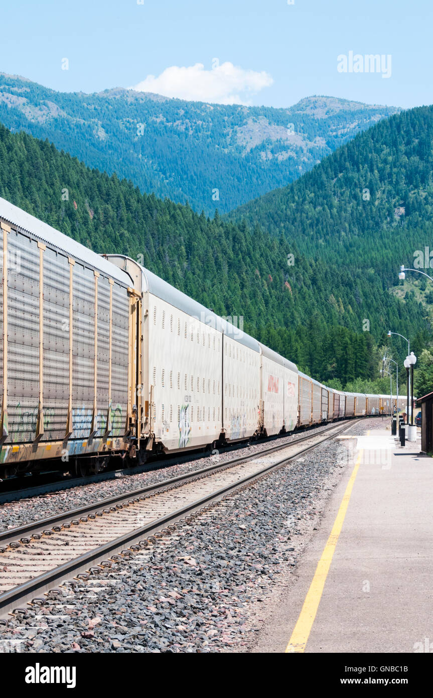 Ein lange amerikanischer Güterzug durchläuft die kleine Station West Glacier in Montana. Stockfoto