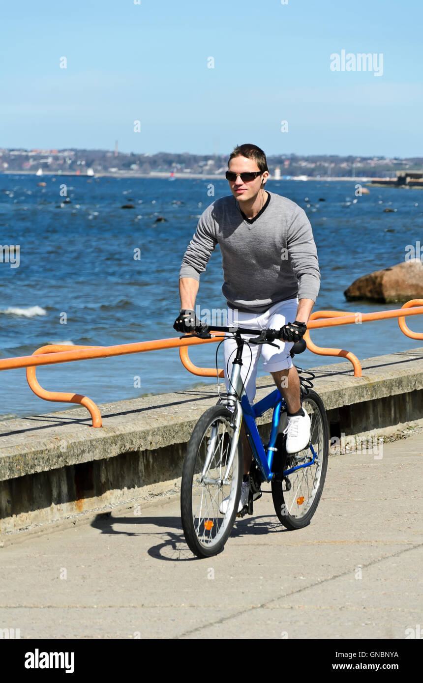 Porträt von hübscher Mann mit dem Fahrrad am Meer Stockfoto