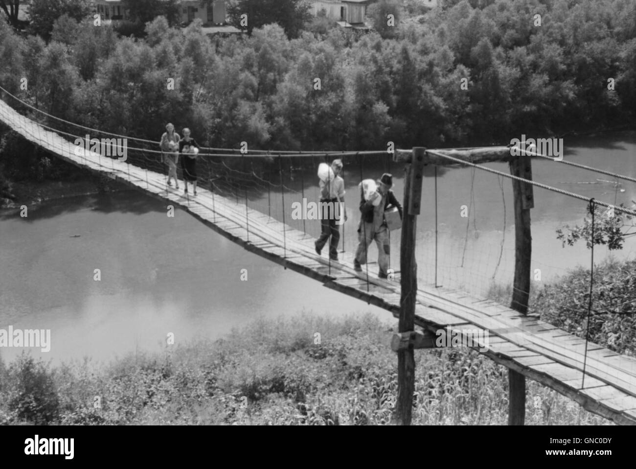 Einfamilienhaus mit Lebensmittel und Vorräte über schwingende Fußgängerbrücke über River in der Nähe von Jackson, Kentucky, Marion Post Wolcott für Farm Security Administration, August 1940 Stockfoto