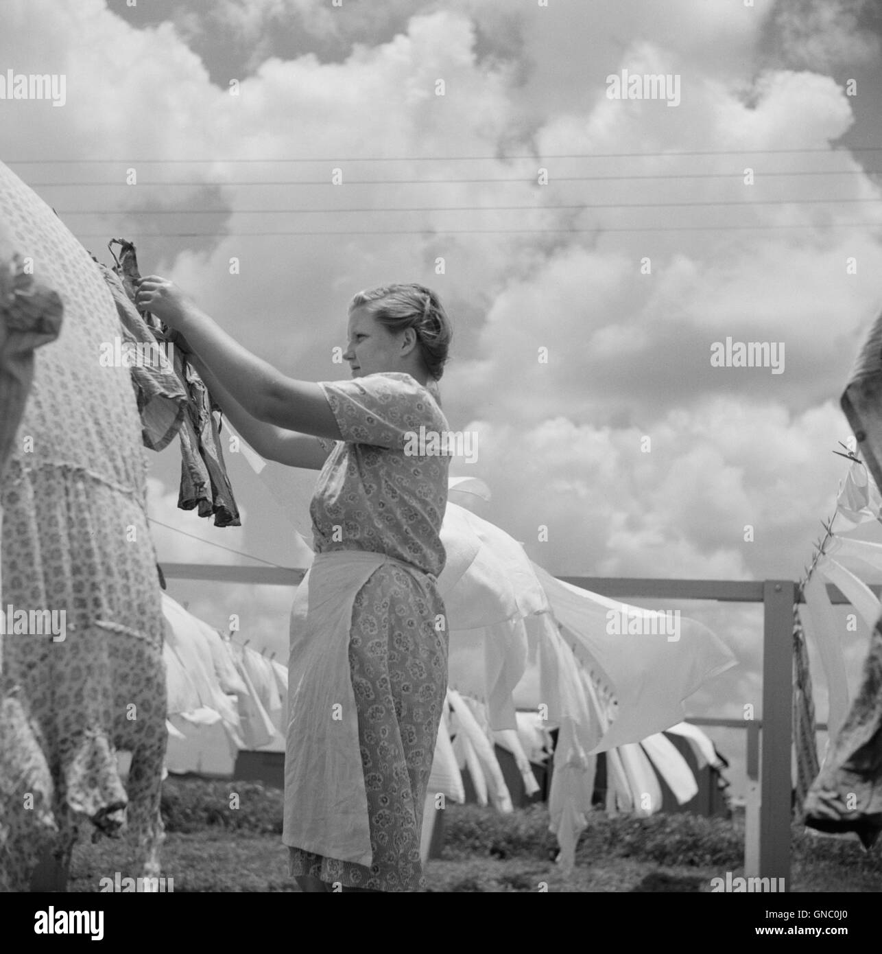Junge Frau hängende Kleidung auf der Wäscheleine im Community Wäscherei Anlage, Osceola wandernden Camp, Belle Glade, Florida, USA, Marion Post Wolcott für Farm Security Administration, Juni 1940 Stockfoto