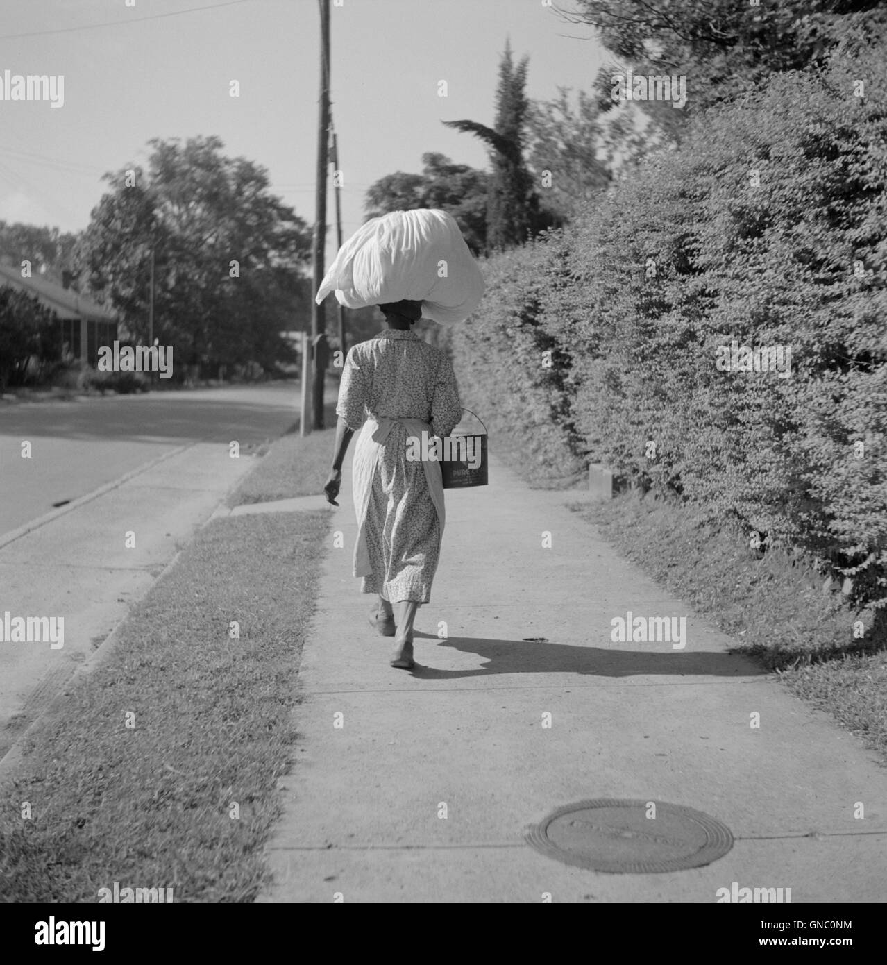 Frau trägt Sack der Wäsche auf ihrem Kopf, Rückansicht, Natchez, Mississippi, USA, Marion Post Wolcott für Farm Security Administration, August 1940 Stockfoto