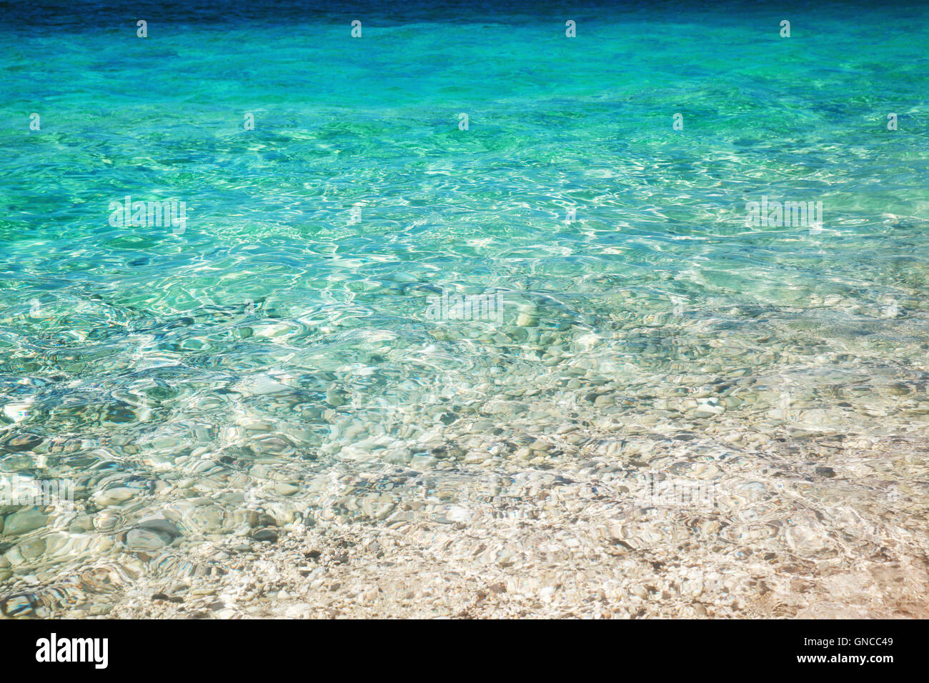 Meer Wasseroberfläche mit Küsten Kiesel unter ihm, Foto Hintergrundtextur Stockfoto