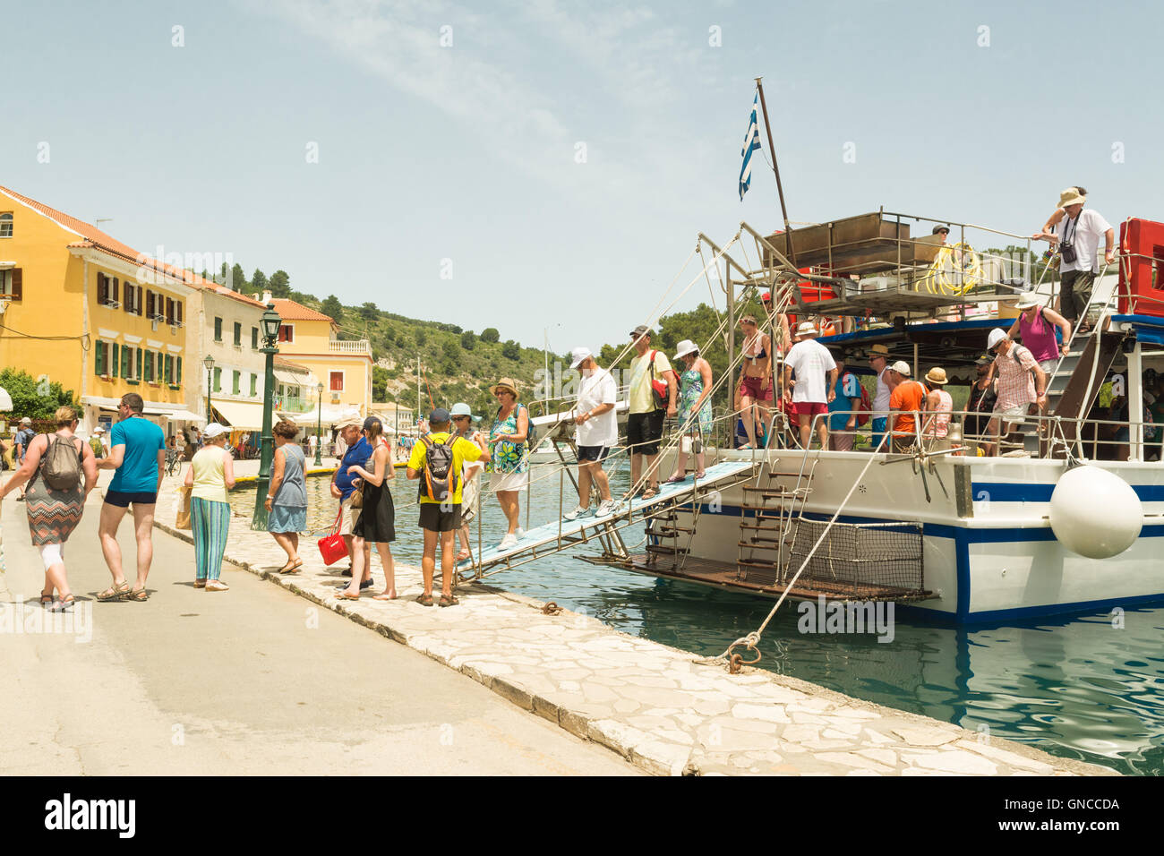 Gaios, Paxos, Griechenland - Touristen, die in Gaios - der wichtigste Hafen auf Paxos, eine der Ionischen Inseln - mit dem Boot Stockfoto