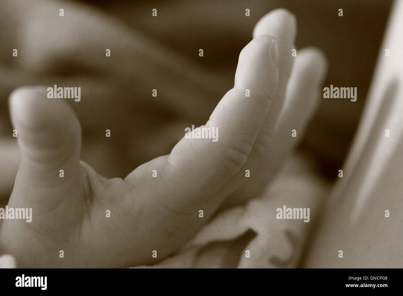 Sepia Bild eines Babys Hand. Stockfoto