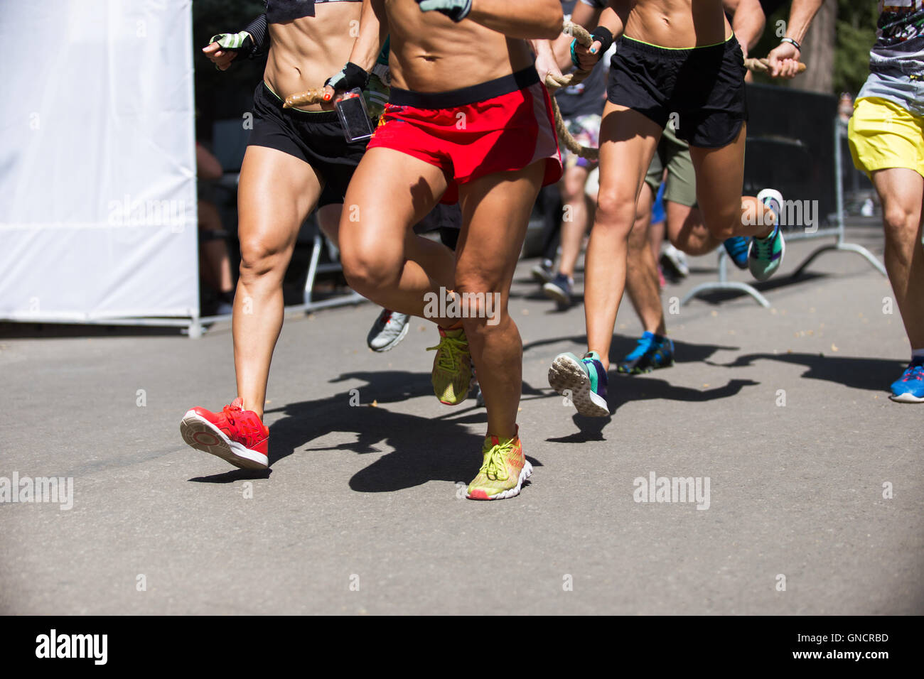 Laufende Menschen auf den Crossfit Wettbewerb, Füße auf der Straße Nahaufnahme Foto Stockfoto