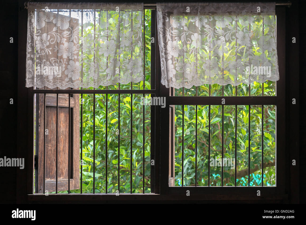 Alten Stil Thai Fenster mit Top-halb Spitzevorhang. Stockfoto